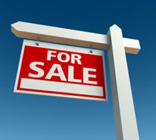 for sale sign in front of blue sky