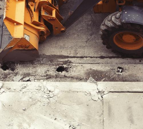 Construction vehicle ties next to sidewalk