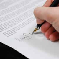 Close up of someone signing document