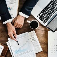 Business Person pointing at Analysis sheet 