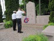 Soldiers giving salute next to wreath